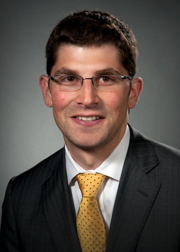 David Seligman wearing a striped suit and gold tie